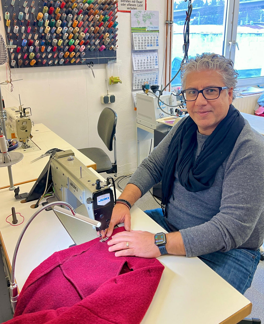 zufriedener Mann an Nähmaschine