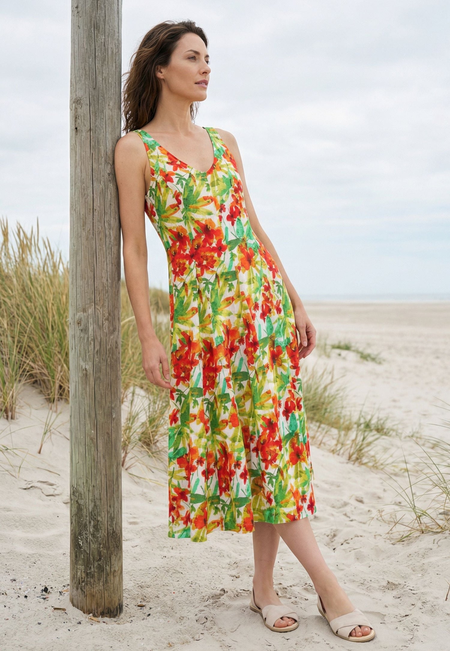 Frau mit Blumenkleid in rot, gelb grün am Strand