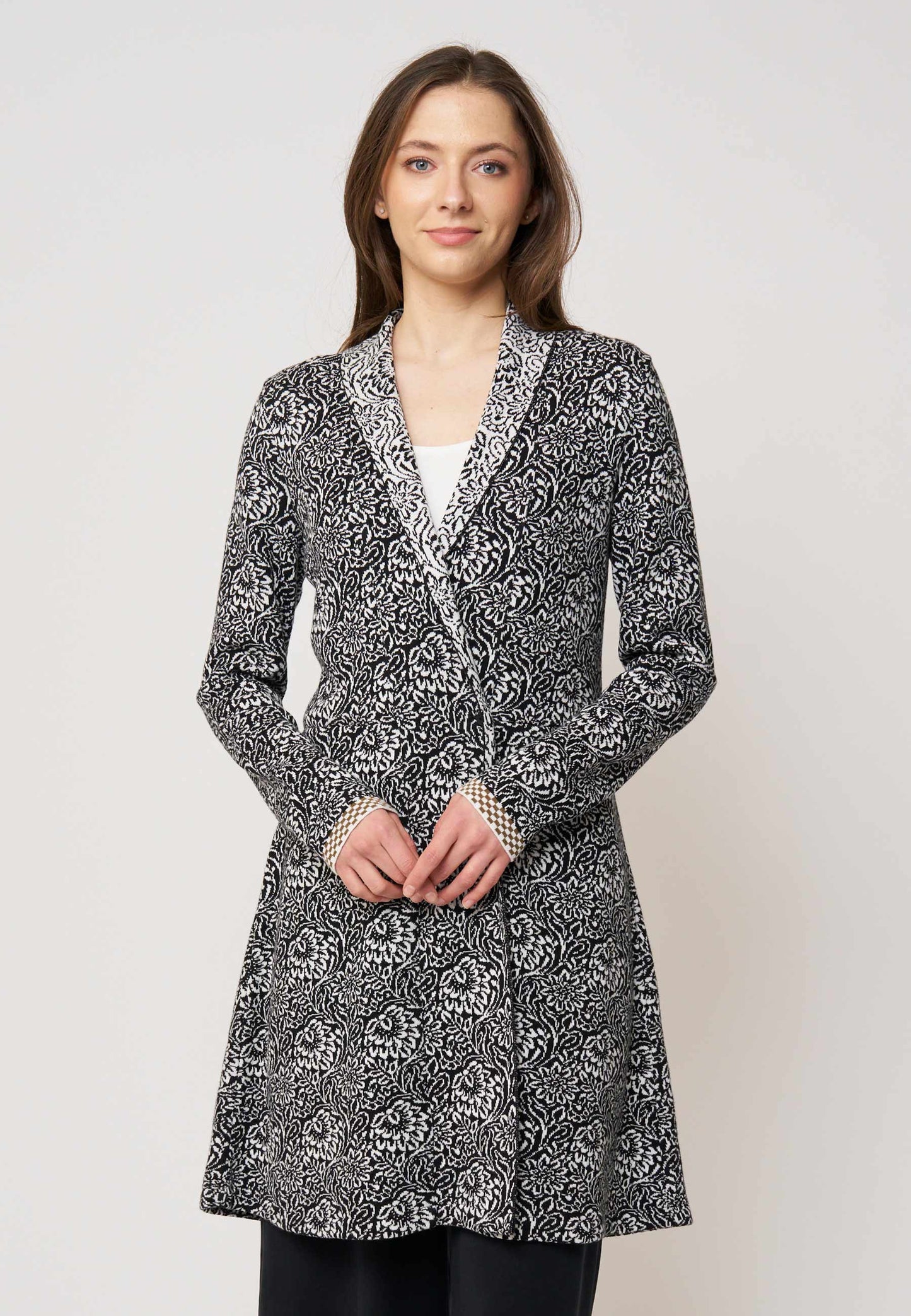 Strickjacke, Modell Jolina lang in Schwarz mit cremefarbenem floralen Muster, frontale Ganzkörperaufnahme getragen