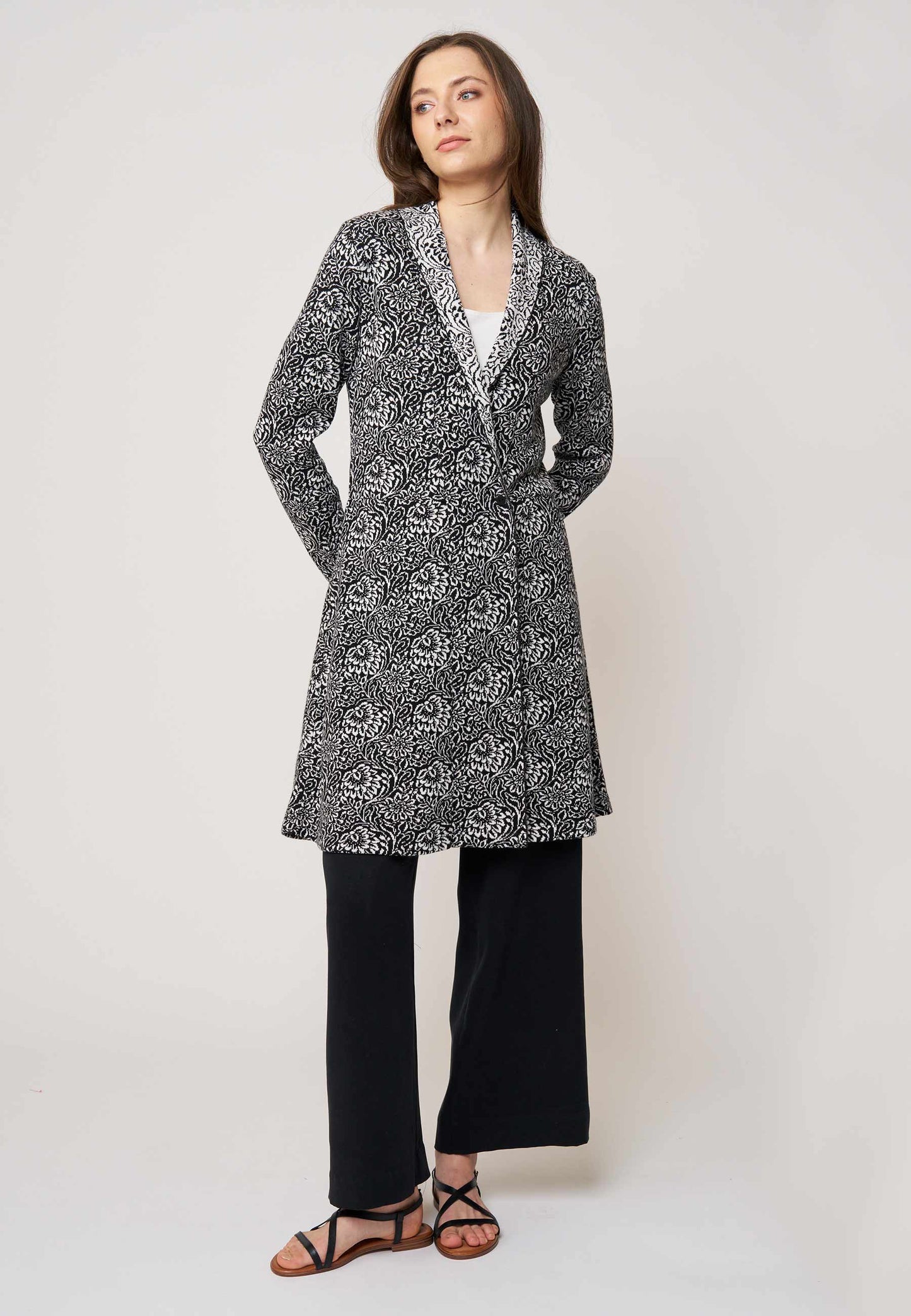 Strickjacke, Modell Jolina lang in schwarz-ecru mit floralem Muster, seitliche Ansicht, langärmelig getragen