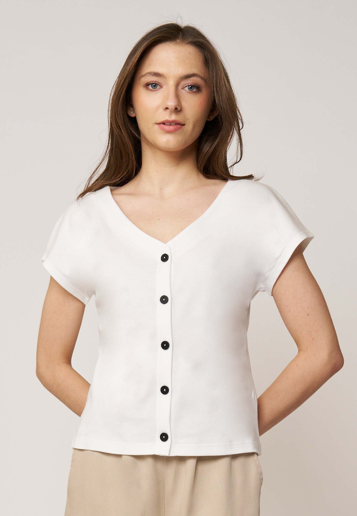 Shirt, Modell Edda in schlichtem Weiß mit kurzem Arm, V-Ausschnitt und dekorativen schwarzen Knöpfen für eleganten Minimalismus