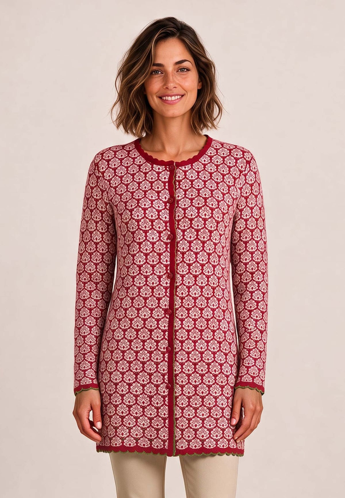 Frau trägt Jacke Eva, Modell lang, mit rotem Blumenmuster und beiger Hose vor hellem Hintergrund