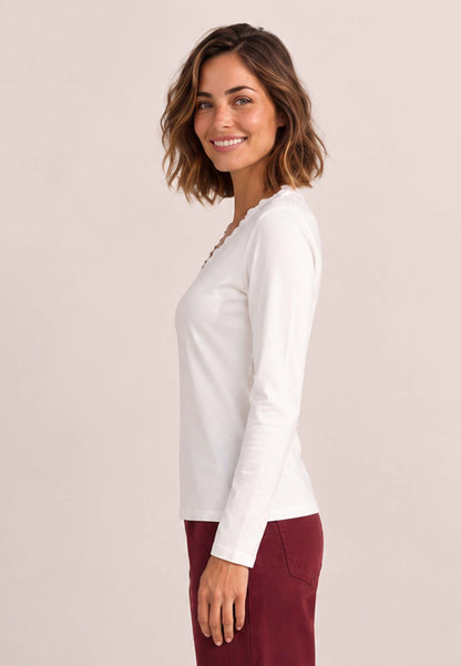 Shirt, Modell Conny an lächelnder Frau im weißen Langarmshirt und bordeauxroter Hose
