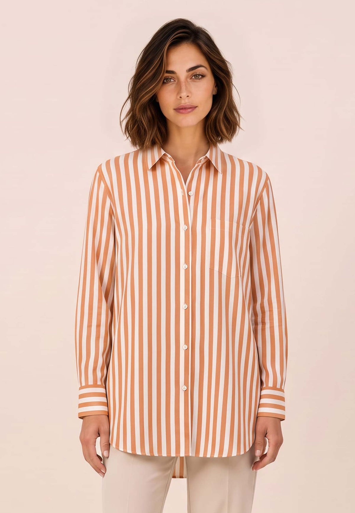 Bluse, Modell Arden mit orange weißem Streifenmuster an Frau mit beiger Hose