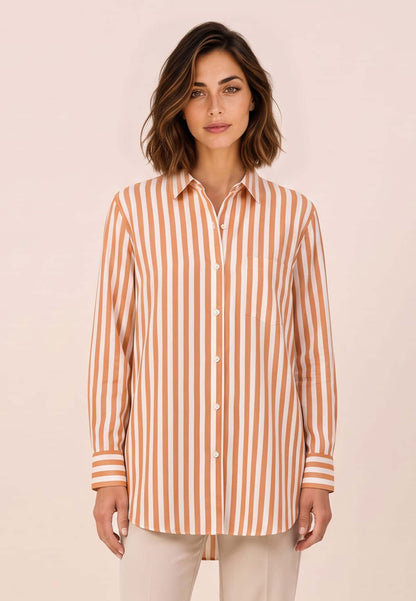 Bluse, Modell Arden mit orange weißem Streifenmuster an Frau mit beiger Hose