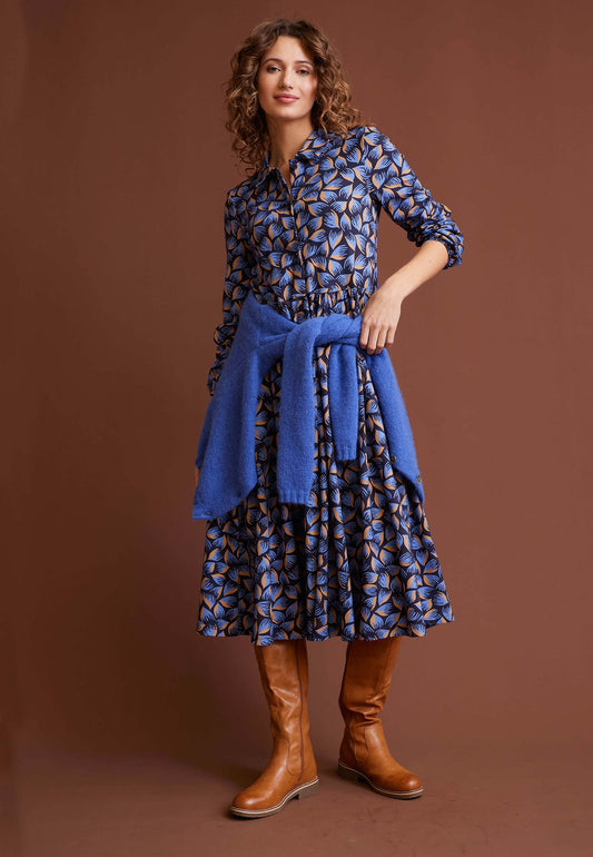 Kleid, Modell Kendra mit blau-braunem Muster an Frau mit blauem Pullover und braunen Stiefeln